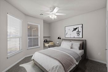 A bedroom with a bed and a ceiling fan